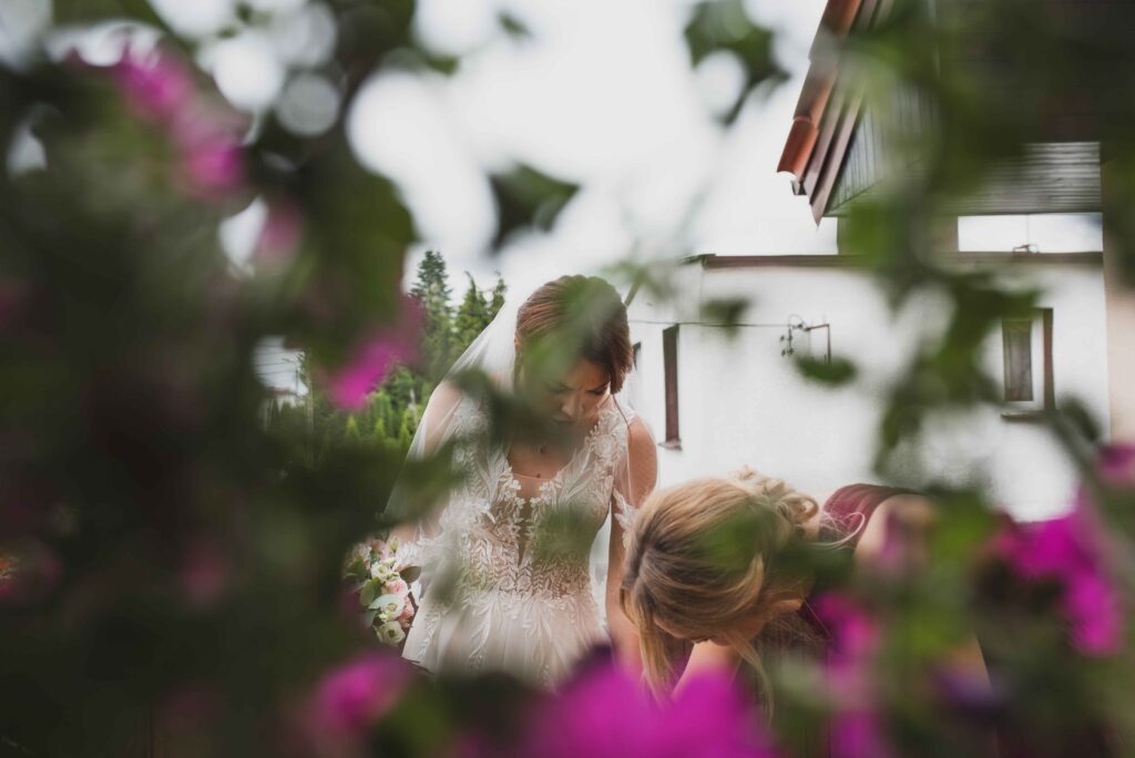 panna młoda pośród kwiatów stoi na balkonie