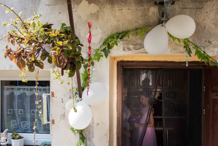 bardzo stary i zniszczony dom panny młodej w progu którego powieszono ślubną suknię