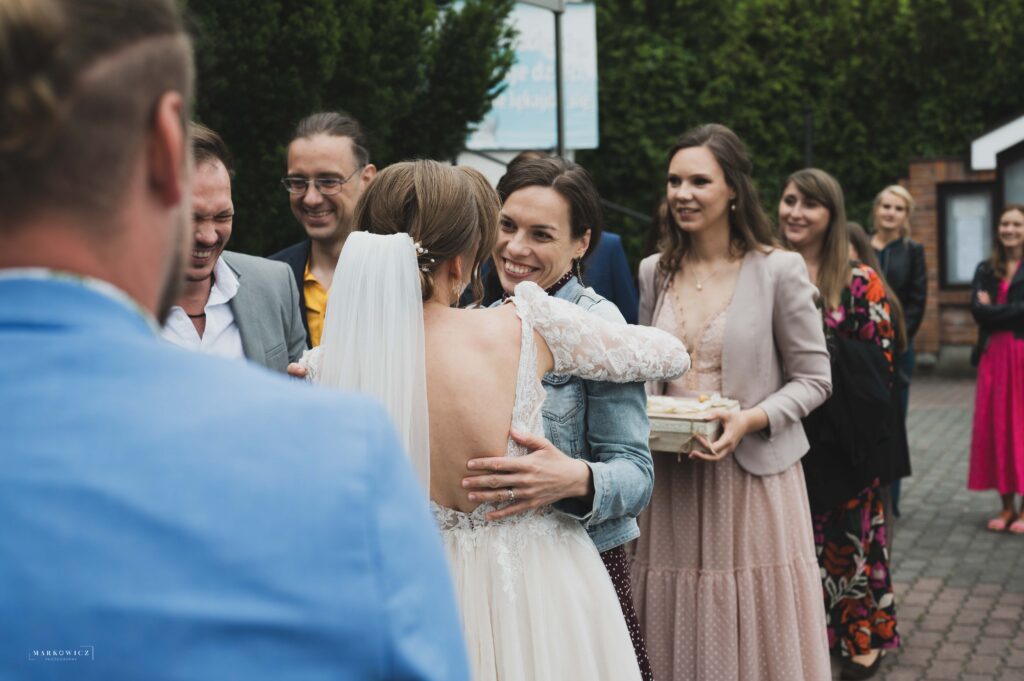 Gratulacje po ślubie, goście ściskają parę, ceremonia ślubna