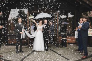 Para młoda przed salą weselną obsypywana konfetti przed restauracją Stary Tartak – reportaż ślubny, fotograf ślubny Olsztyn.