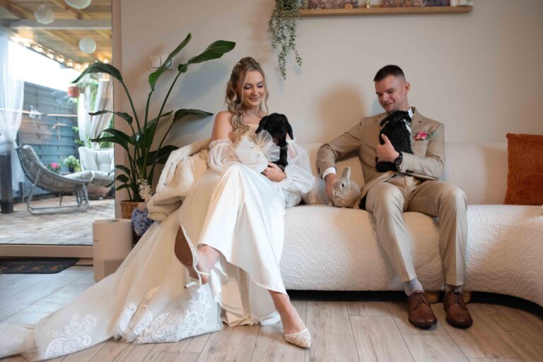 Para młoda siedzi na kanapie w trakcie przygotowań trzymając na rękach swoje ukochane króliki